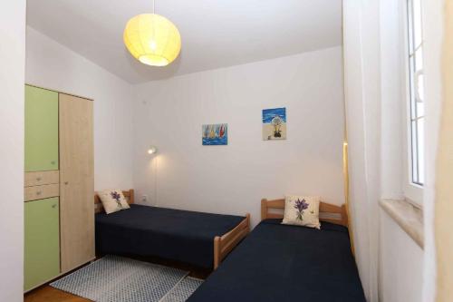 a small bedroom with two beds and a window at Apartment in Silo/Insel Krk 13416 in Šilo
