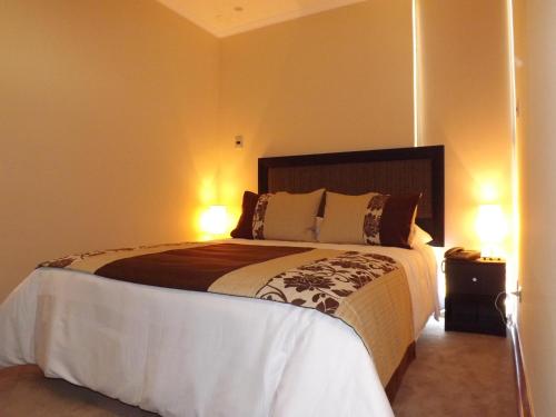a bedroom with a large bed with two lamps at Nuevo Hotel Constitucion in Constitución
