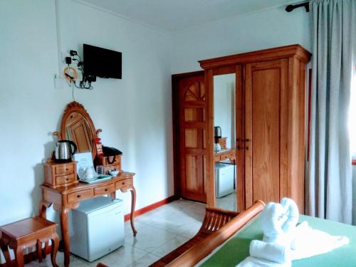 a bedroom with a bed and a table and a desk at Lucy's guesthouse in La Digue