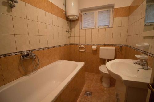 a bathroom with a tub and a toilet and a sink at Apartment Kampor 4 in Kampor
