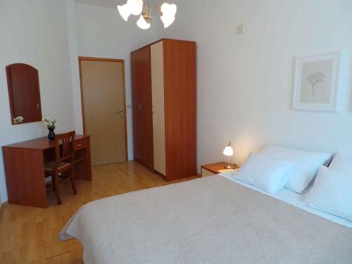 a bedroom with a bed and a desk and a cabinet at Apartment Liznjan 2 in Ližnjan