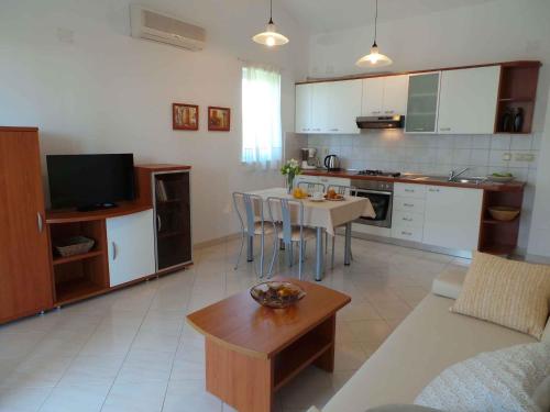 a kitchen and living room with a table and a couch at Apartment Liznjan 2 in Ližnjan