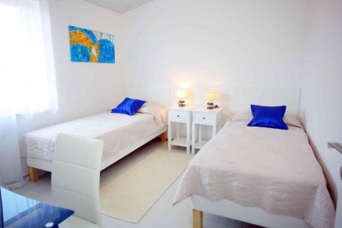 a bedroom with two beds with blue pillows at Apartment Banjole 1 in Banjole