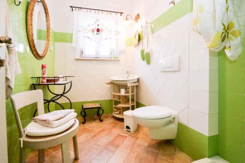 a green and white bathroom with a toilet and a sink at Holiday home in Liznjan/Istrien 8962 in Ližnjan