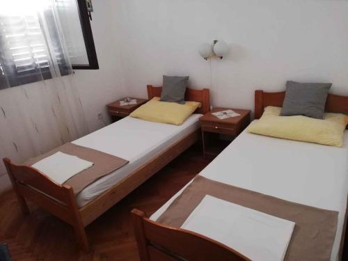 a room with two beds and two tables at Apartment in Petrcane/Zadar Riviera 7866 in Petrcane