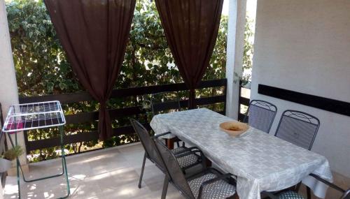 a table and chairs sitting on a balcony with a table and chairs at Apartment in Petrcane - Zadar Riviera 7866 in Petrcane