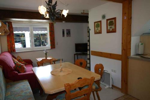 シュトローブルにあるHoliday home Strobl - Salzburger Land 103の木製のテーブルとキッチンのあるリビングルーム