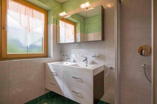 ein Bad mit einem Waschbecken und einem Spiegel in der Unterkunft Apartment Zell am Ziller/Zillertal 841 in Zell am Ziller