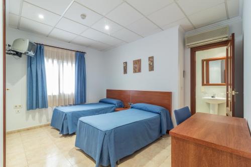 a hospital room with two beds and a table at Hotel Reig in Pego