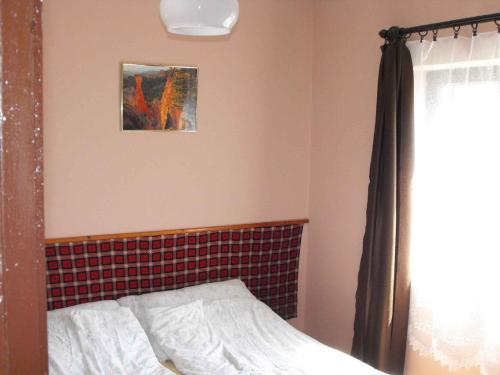 バラトンマーリアフュルドゥーにあるHoliday home in Balatonmariafürdo 19426のベッドルーム1室(ベッド1台付)が備わります。壁に絵が飾られています。