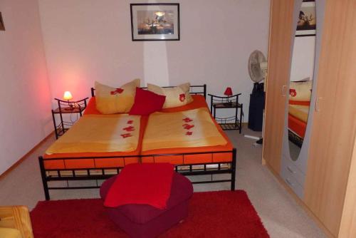 - une chambre avec 2 lits et des oreillers rouges dans l'établissement Apartment Fuhlendorf 2, à Bodstedt