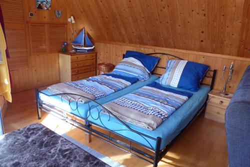 ein Schlafzimmer mit einem Bett mit blauen Kissen darauf in der Unterkunft Apartment Fuhlendorf 1 in Bodstedt