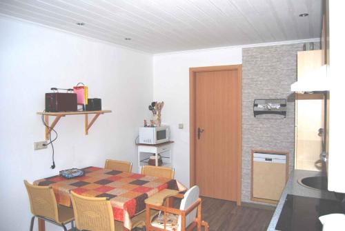 Holiday home Ummanz 1 في Lieschow: مطبخ وغرفة طعام مع طاولة وكراسي