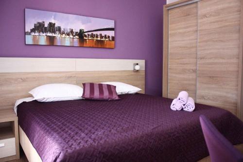 a bedroom with a purple bed with shoes on it at Apartment in Grebastica 7034 in Grebaštica