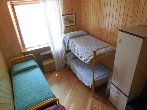 Ronzo ChienisにあるApartment in Mori 24151のベッド2台と窓が備わる小さな客室です。