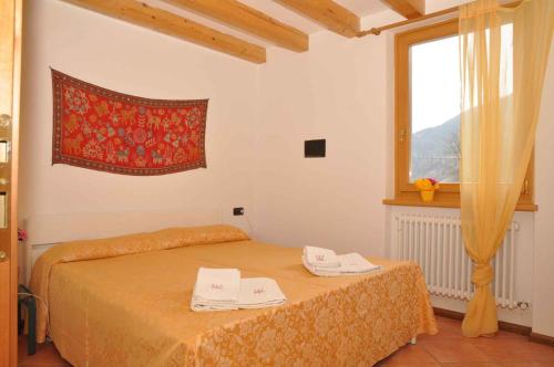 レードロにあるHoliday home in Pieve di Ledro 22670の窓とベッドカバーが備わるドミトリールームのベッド1台分です。