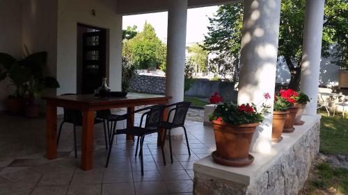 a patio with a table and chairs and plants at Studio in Starigrad-Paklenica 6776 in Starigrad-Paklenica