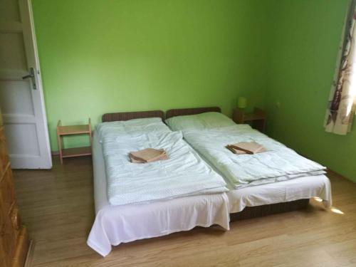 Una cama en una habitación verde con dos cajas. en Holiday home in Gyenesdias/Balaton 18865, en Gyenesdiás
