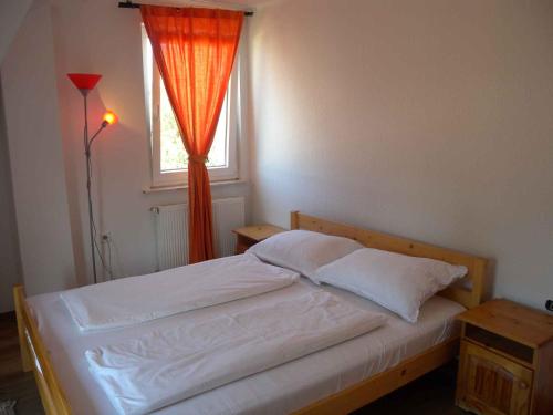 a bedroom with a bed with an orange curtain and a window at Holiday home in Siofok - Balaton 20063 in Siófok