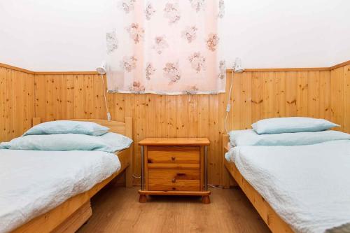バラトンベレーニにあるApartment in Balatonbereny/Balaton 18050の木製の壁の客室で、ツインベッド2台が備わります。