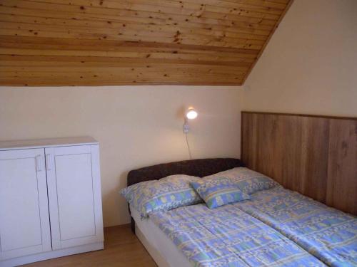 バラトンケレストゥールにあるHoliday home in Balatonmariafürdo 33086の木製の天井が特徴のベッドルーム1室(ベッド1台付)