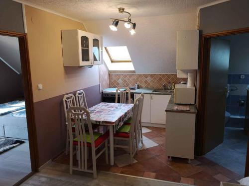 Apartment Balatongyorok 3 في بالاتونغيوروك: مطبخ صغير مع طاولة وكراسي في الغرفة