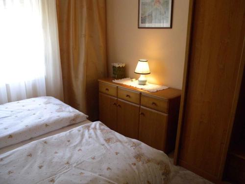 バラトンフェニヴェシュにあるApartments in Balatonfenyves/Balaton 18466のベッドルーム1室(ベッド1台、ドレッサーのランプ付)