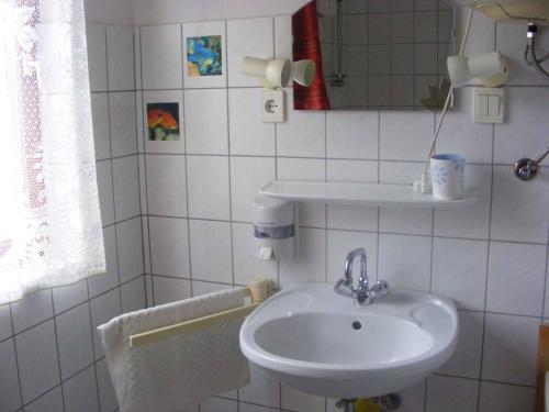a white bathroom with a sink and a mirror at Holiday home Cserszegtomaj - Balaton 18288 in Cserszegtomaj