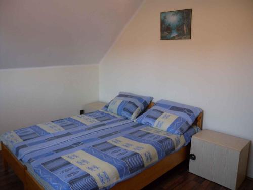 1 dormitorio con 1 cama con mantas y almohadas azules en Holiday home Balatonbereny/Balaton 18113, en Part