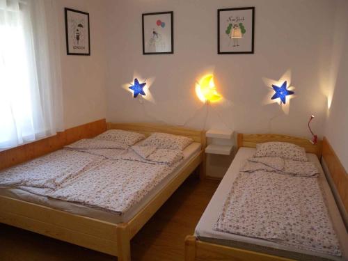 - 2 lits dans une chambre avec des étoiles sur le mur dans l'établissement Holiday home in Fonyod/Balaton 18622, à Balatonfenyves