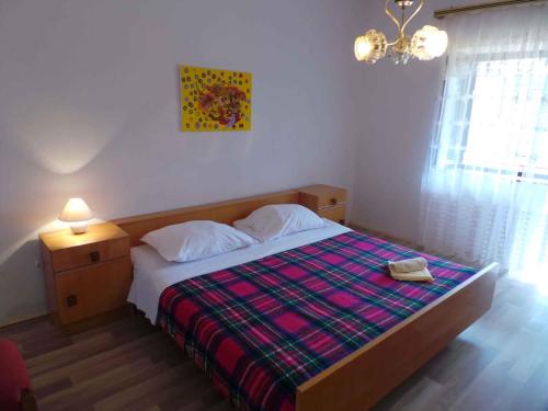 - une chambre avec un lit doté d'une couverture et d'une lampe dans l'établissement 4-Bedroom Holiday home in Grižane/Crikvenica Riviera 15315, à Grižane