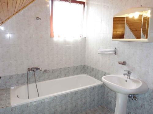 a bathroom with a bath tub and a sink at Holiday home in Balatonmariafürdo 19326 in Balatonmáriafürdő