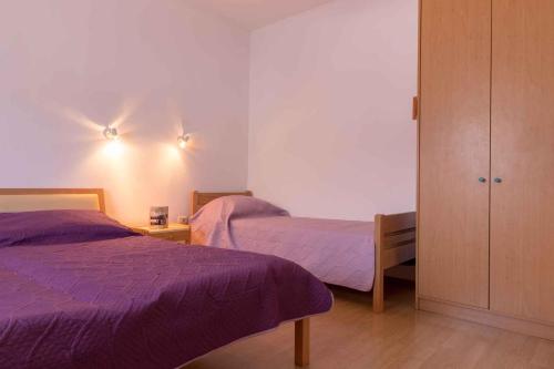 a bedroom with two beds and a closet with purple sheets at Apartment in Pula/Istrien 11168 in Veli Vrh