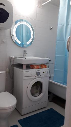 y baño con lavadora y lavamanos. en Светлая квартира для гостей, en Kyzylorda