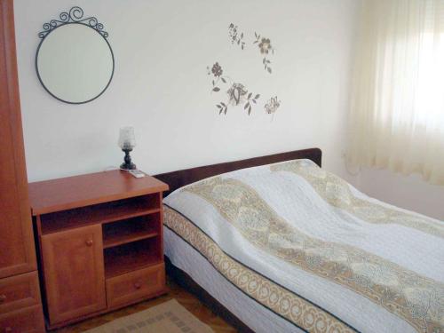 Schlafzimmer mit einem Bett, einer Kommode und einem Spiegel in der Unterkunft Apartment Medulin 12 in Medulin