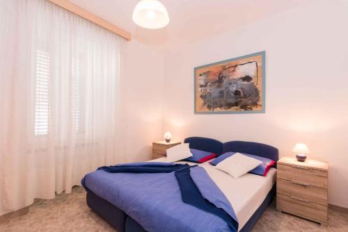 a bedroom with a large bed with a blue bedspread at Apartment in Plomin/Istrien 8771 in Plomin