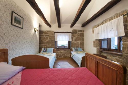 a bedroom with three beds and two windows at Holiday home in Buzet - Istrien 9974 in Buzet