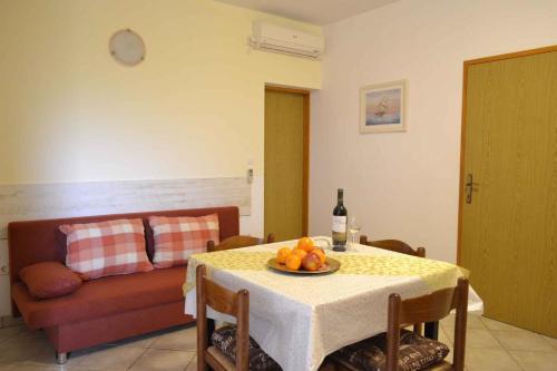 a table with a plate of fruit and a couch at Apartment Valbandon 3 in Štinjan