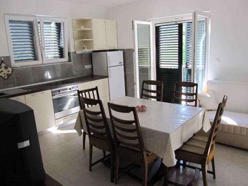 eine Küche mit einem Tisch und Stühlen im Zimmer in der Unterkunft Apartment in Supetar/Insel Brac 5905 in Supetar