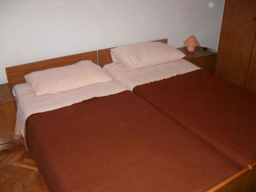 ein Bett mit zwei Kissen auf einem Zimmer in der Unterkunft Apartment Zaglav 2 in Zaglav