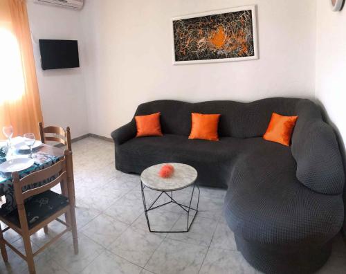 Apartment Trogir 1 في أوكرونغ دونغي: غرفة معيشة مع أريكة سوداء وطاولة