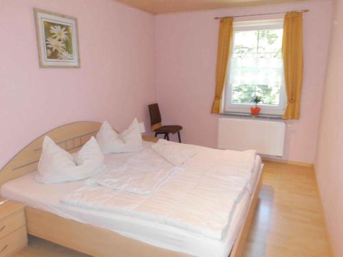 Schlafzimmer mit einem Bett mit weißer Bettwäsche und einem Fenster in der Unterkunft Apartment Sayda 4 in Pilsdorf