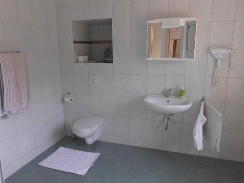 a white bathroom with a toilet and a sink at Apartment Sayda 4 in Pilsdorf