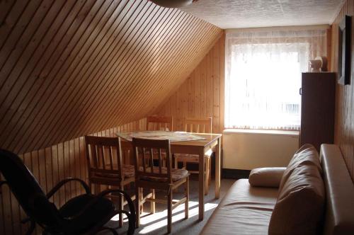 ein Wohnzimmer mit einem Tisch, Stühlen und einem Sofa in der Unterkunft Apartment Neuendorf - Hiddensee 2 in Neuendorf