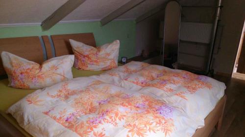 a bed with a white comforter with flowers on it at Apartment in Sehlen - Insel Rügen 3067 in Sehlen