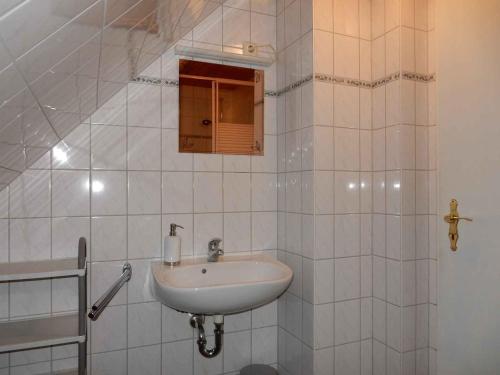 W białej łazience znajduje się umywalka i lustro. w obiekcie Apartment in Fuhlendorf 2747 w mieście Gutglück
