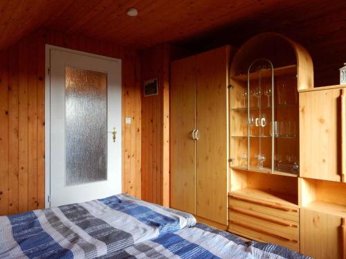 a bedroom with a bed and wooden walls and a window at Apartment in Fuhlendorf 2747 in Fuhlendorf