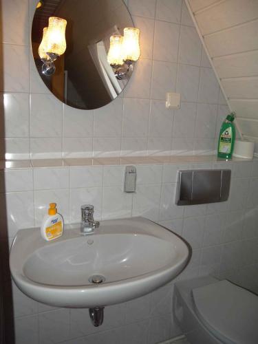 ein Badezimmer mit einem Waschbecken, einem Spiegel und einem WC in der Unterkunft Apartment in Bergen auf Rügen 2835 in Bergen auf Rügen