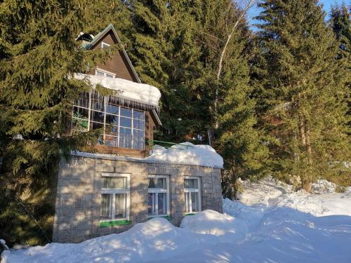 una casa en la nieve con nieve alrededor en Holiday home in Harrachov 2311, en Harrachov