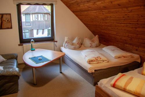 Zimmer mit 2 Betten, einem Tisch und einem Fenster in der Unterkunft Apartment Harrachov 3 in Harrachov